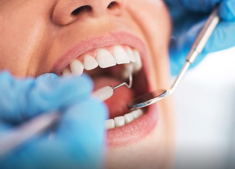Dentysta sprawdzający stan uzębienia pacjentki